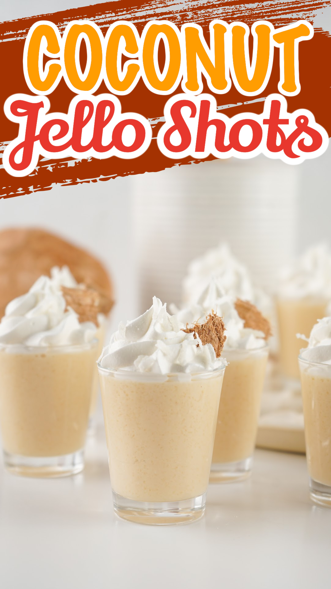Coconut jello shots topped with whipped cream in tall shot glasses. pin image