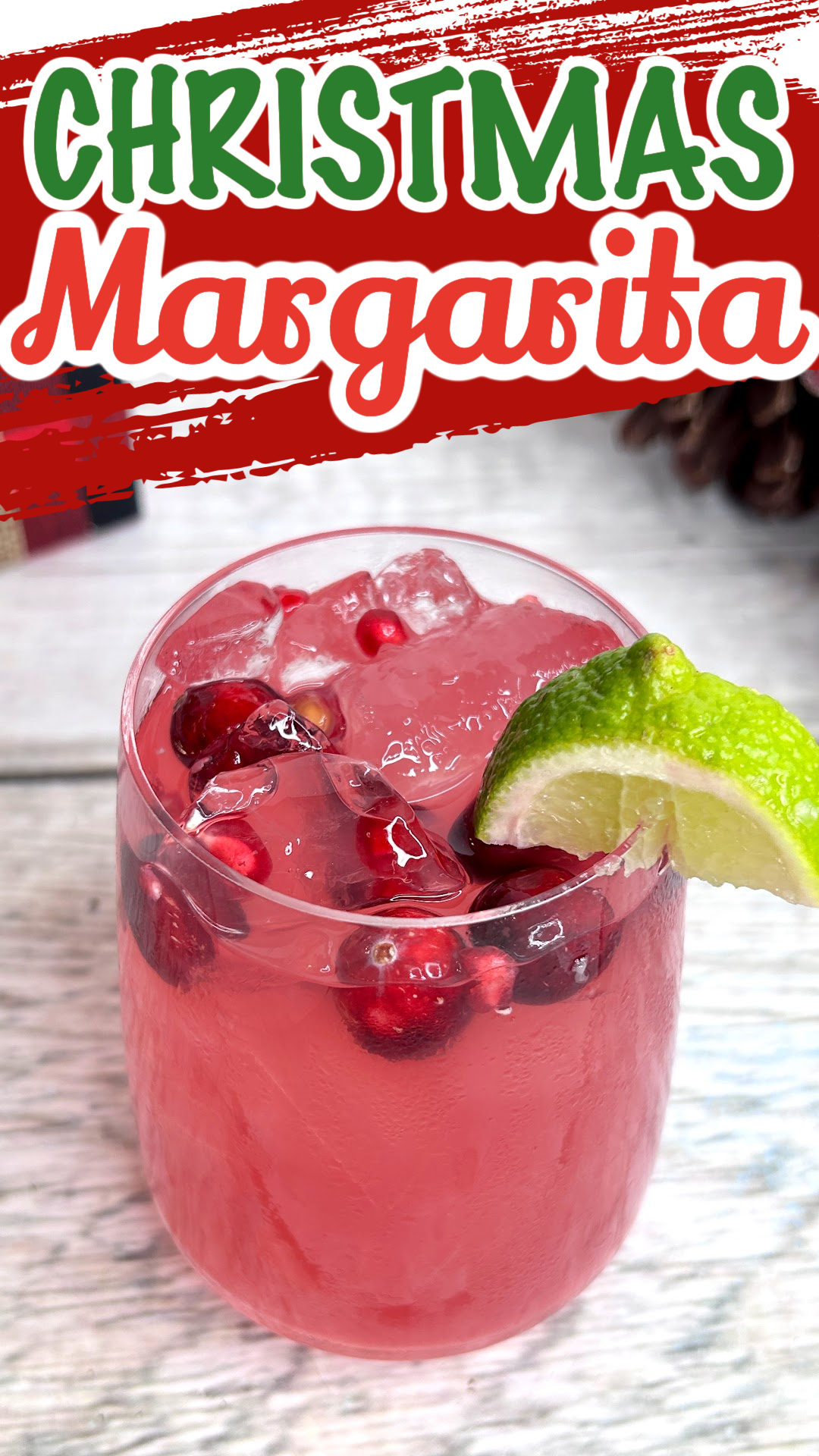 Pin image of a Christmas margarita with fresh cranberries and a lime wedge as garnish.