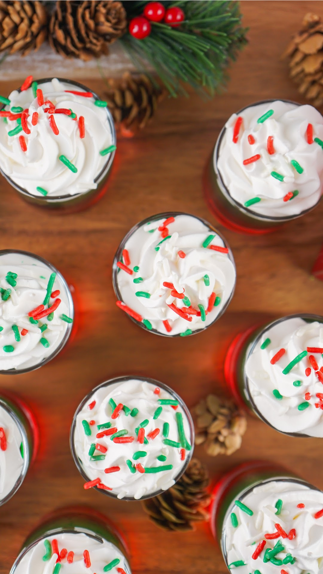 Looking down from the top at Christmas jello shots with whipped cream and Christmas sprinkles