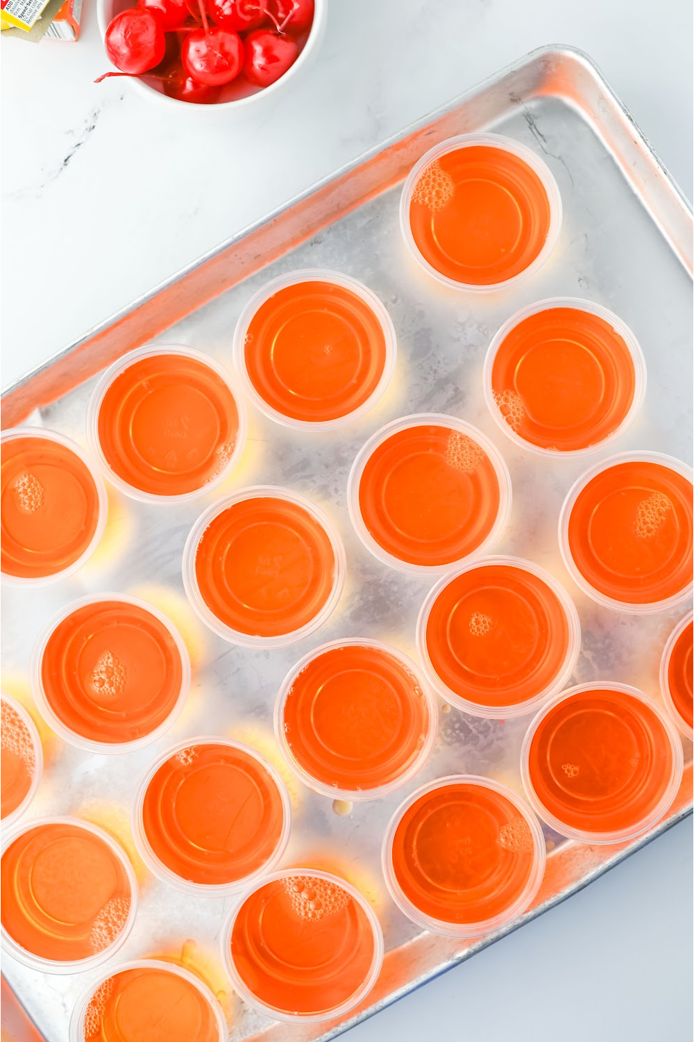 chill jello shots in the refrigerator on a tray.