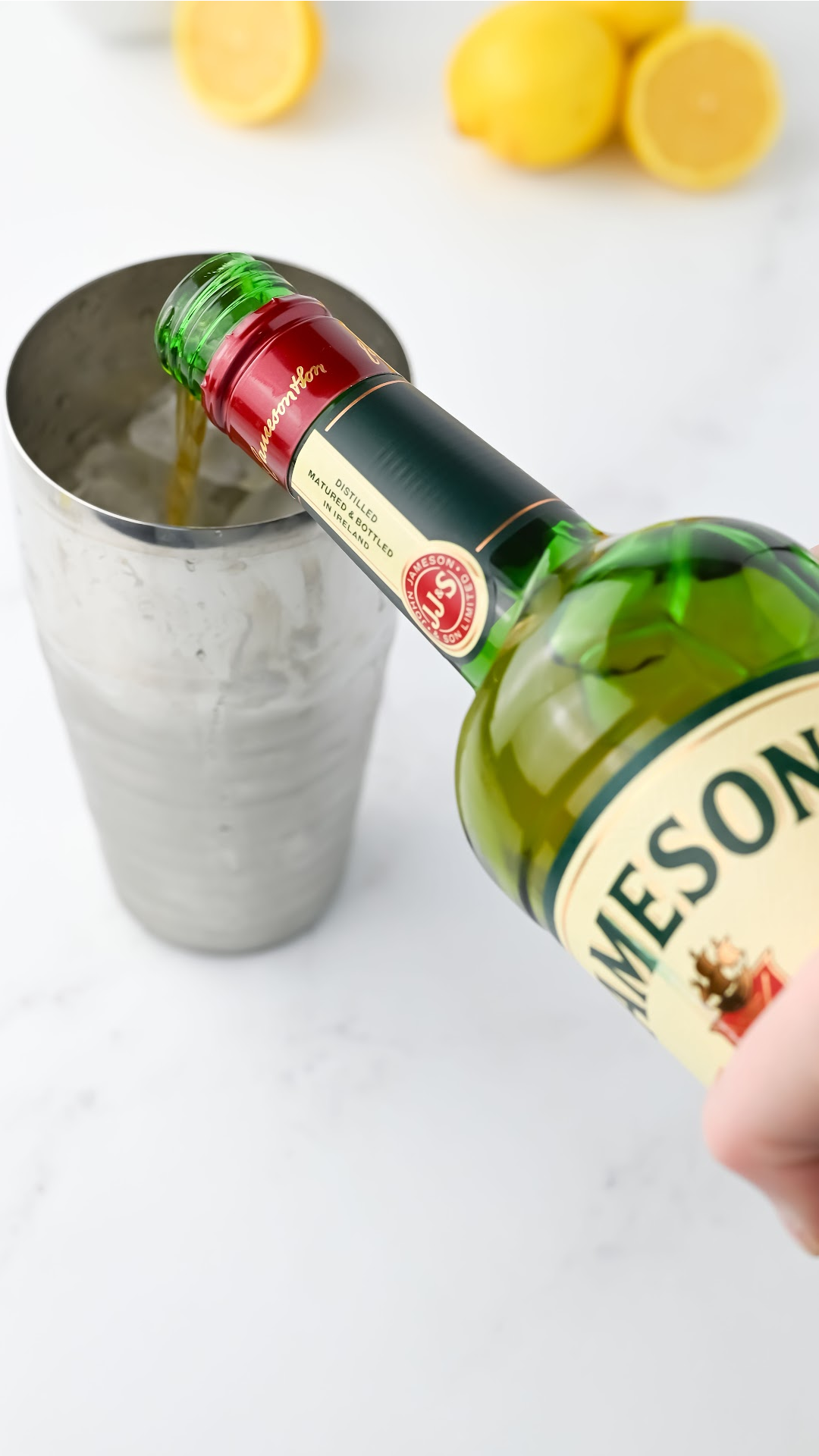 Pouring Jameson whiskey into a cocktails shaker.