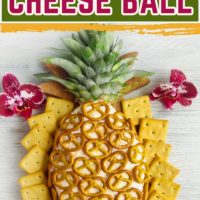 A pineapple-shaped Hawaiian cheese ball covered with mini pretzels and garnished with pineapple leaves, surrounded by square crackers on a white wooden surface. Text overlay reads 'Pineapple Hawaiian Cheese Ball' with the website ohmy-creative.com.