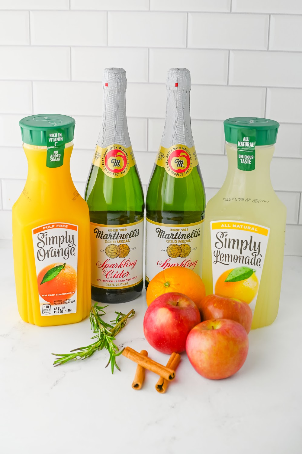 Bottles of ingredients to make harvest fall punch including juices and apple cider.
