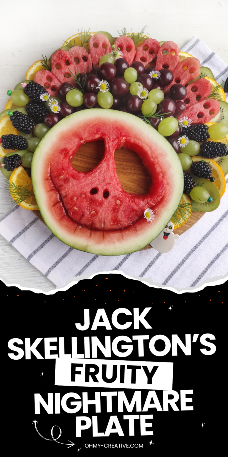This image shows a spooky and creative fruit platter styled like Jack Skellington’s face using watermelon, grapes, blackberries, and other colorful fruits.